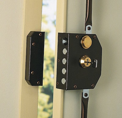 Serrure en applique : coffre fixé à la porte, tringlerie apparente.